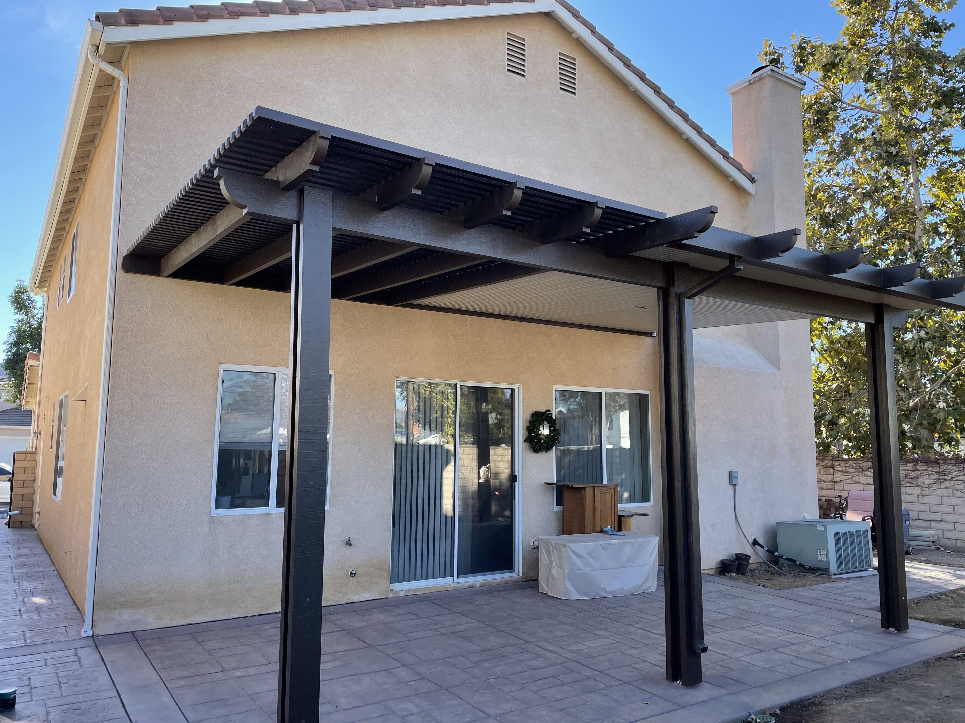 Dark-brown lattice patio cover on a two-story home