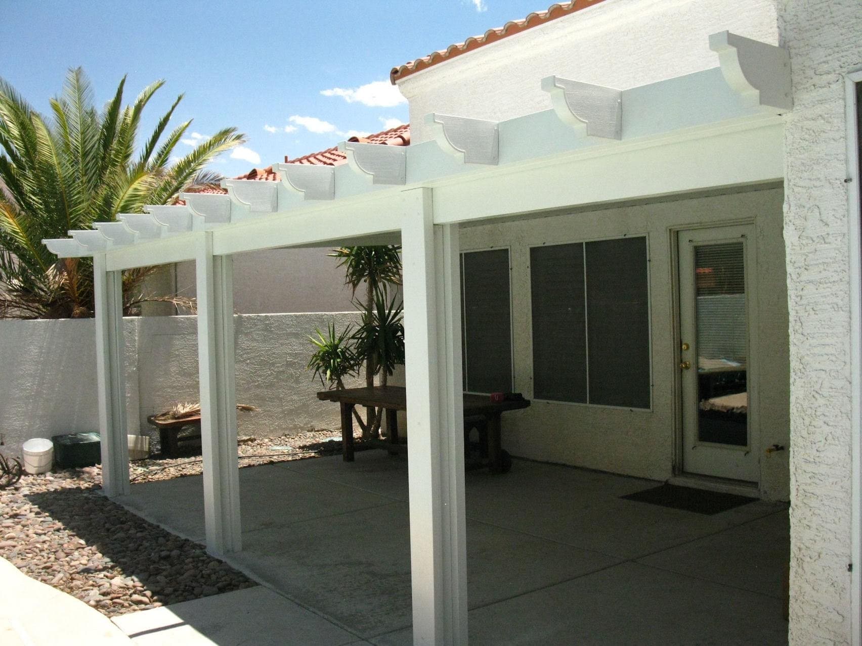 White solid patio cover on a stucco home